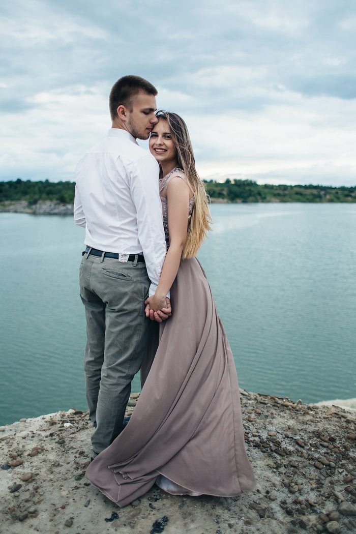 Casal abraçado olhando para o lago