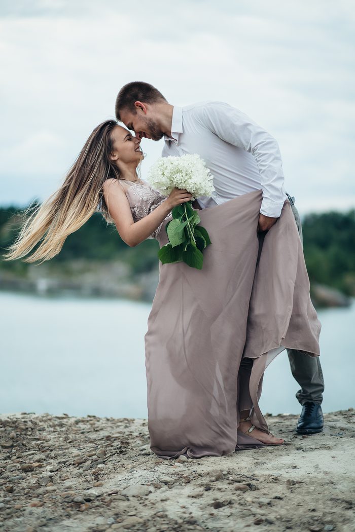 Casal se abraçando com o cabelo da noiva ao vento